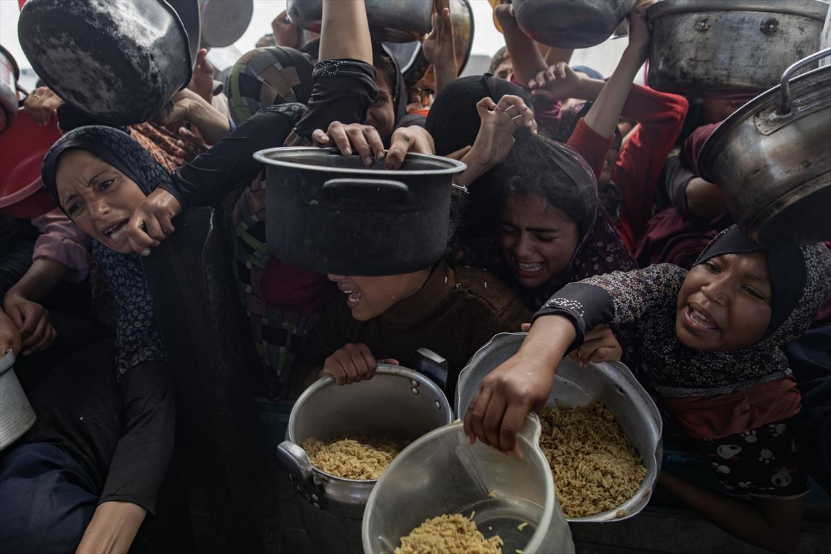 Palestinas luchan por algo de comida en las ya habituales colas del hambre en la Franja. Foto: EFE